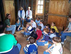 Photo shows school program visitors in Laurel Branch Farmhouse at the National Colonial Farm.