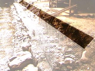 Stabilization of an unstable stream bank utelizing gabions (metal mesh baskets) filled with rocks.