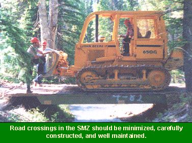Photo of bulldozer using a bridge to cross a stream: Road crossings in the SMZ should be minimized, carefully constructed, and well maintained.
