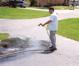 Picture of man watering driveway while trying to water grass