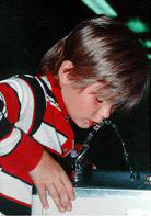 young boy drinking from water fountain